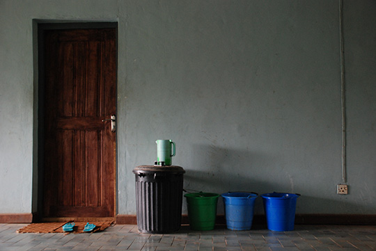 毎朝わたしが部屋の入り口に並べる、井戸から汲み上げた1日分の水　（右に並んでいるような、普通サイズのバケツ約8杯分。左にある黒のふた付きポリバケツには、右に並ぶバケツ4.5杯分の水が入っている）。2009年10月15日　イフェ、モダケケ地区の下宿にて